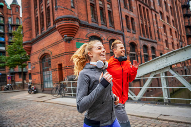 istock Young athletic couple running through city street 1334894366