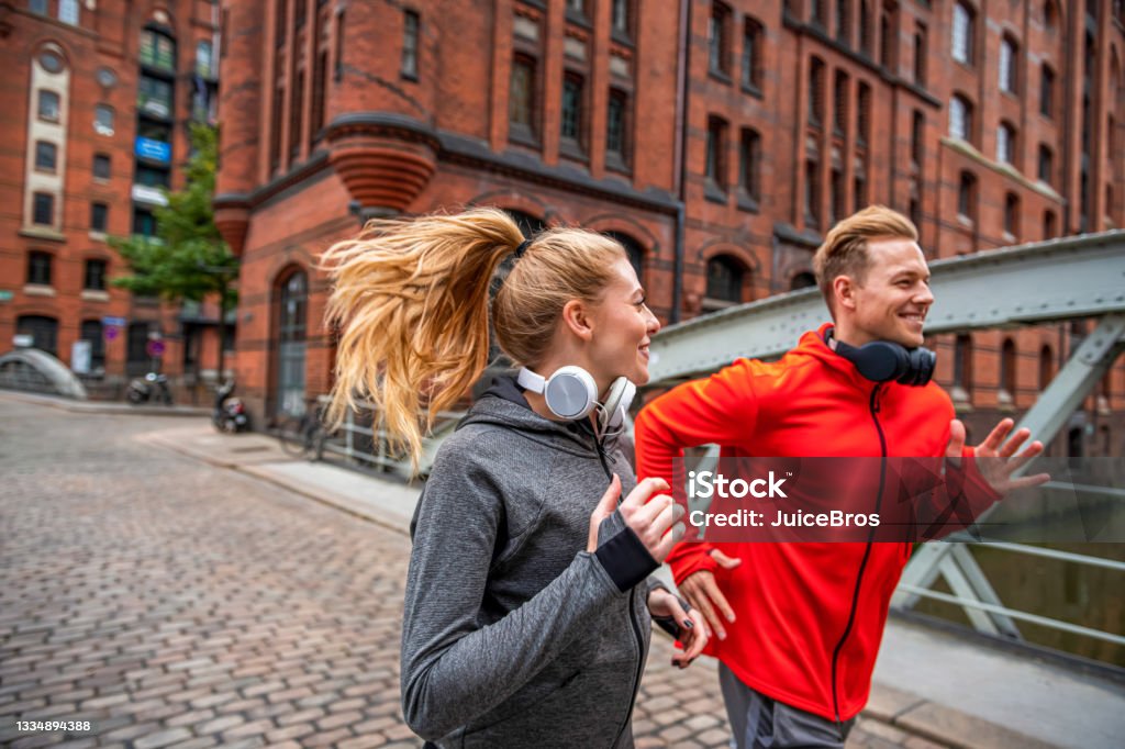 Junges sportliches Paar läuft durch die Stadtstraße - Lizenzfrei Sport Stock-Foto
