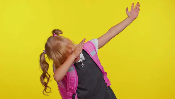 Photo of Trendy school girl having fun dancing and moving to rhythm, dabbing raising hands, dubdance gesture