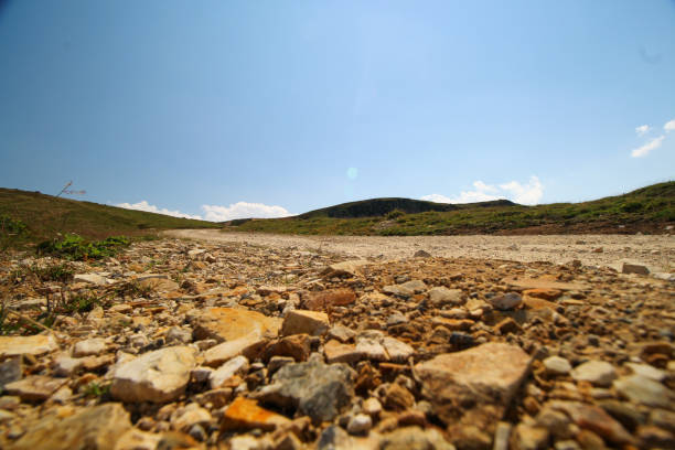 dirt stony road blue sky green mountain