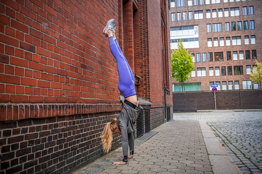 Portrait of athletic woman doing handstand