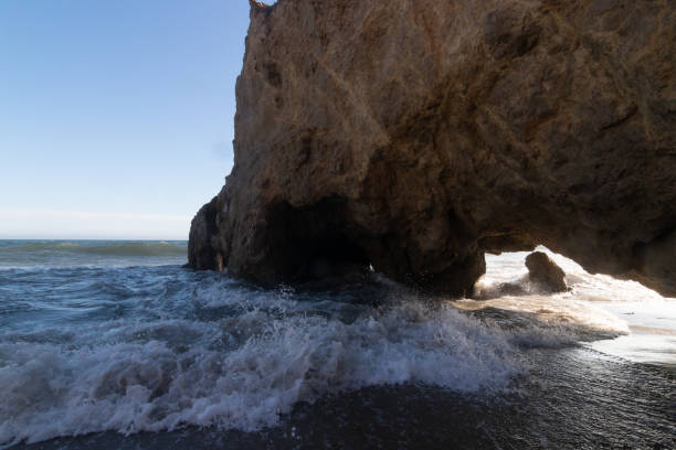 istock Rocks on the beach with waves and sand at sunset 1334905585