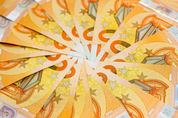 A close-up of €750 in €50 notes all in a clock face spiral with the the numbers in the white boxes edited out and the notes are not fully visible, only seeing part of the note in repetition.