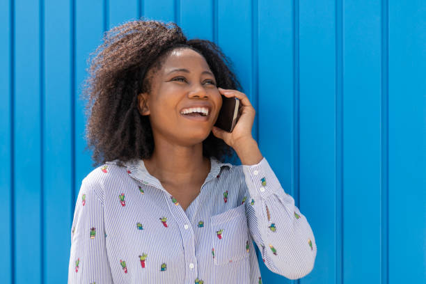 istock Young african woman smiling and using mobile phone 1334908172