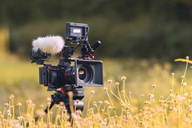 fotocamera digitale e apparecchiature di registrazione del suono sul prato. concetto di storytelling. - studio cinematografico foto e immagini stock