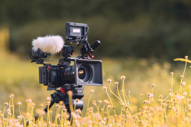 Digital Camera and sound recording equipment on the lawn.Storytelling concept. Digital Camera and sound recording equipment on the lawn.Documentary filming nature and landscapes camera stock pictures, royalty-free photos & images