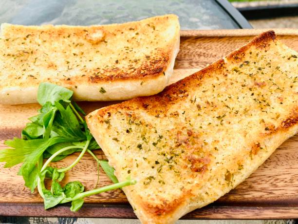 Garlic bread Toasted garlic ciabatta bread served on a wood board ciabatta stock pictures, royalty-free photos & images