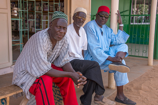 Mbour, Senegal - May 30, 2014: Three men sitting outside a shop in the coastal town of Saly
