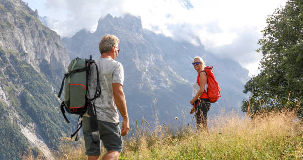 istock Mature couple hike along grassy mountain ridge 1334919466