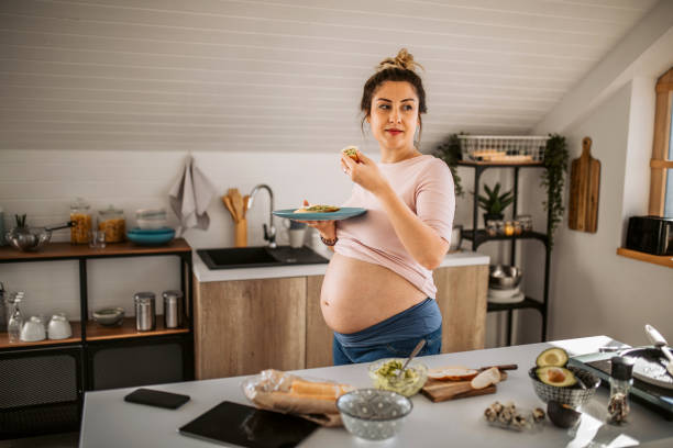 istock Young pregnant woman having breakfast at the kitchen 1334919503