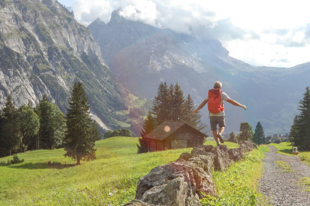 istock Hiker balances as he walks down rock wall near road 1334919507