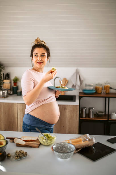 istock Young pregnant woman having breakfast at the kitchen 1334919512