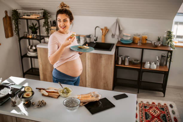 istock Young pregnant woman having breakfast at the kitchen 1334919513