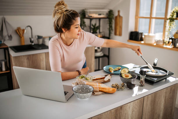 istock Pregnant woman making breakfast and working at home using laptop 1334919520