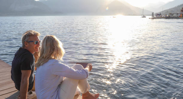 istock Mature couple relax on dock over water, at sunrise 1334920666