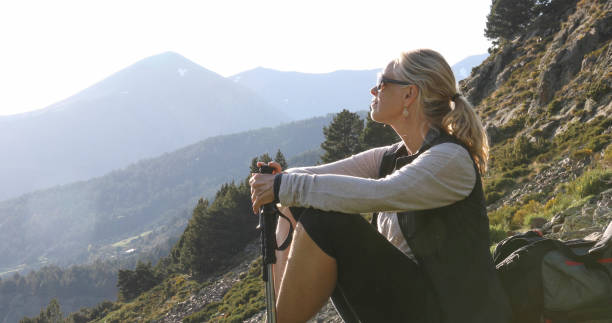Female hiker relaxes on sunny mountain ridge