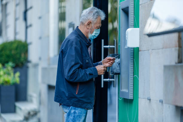 istock Senior Man is Using ATM During a Pandemic Time. 1334923371