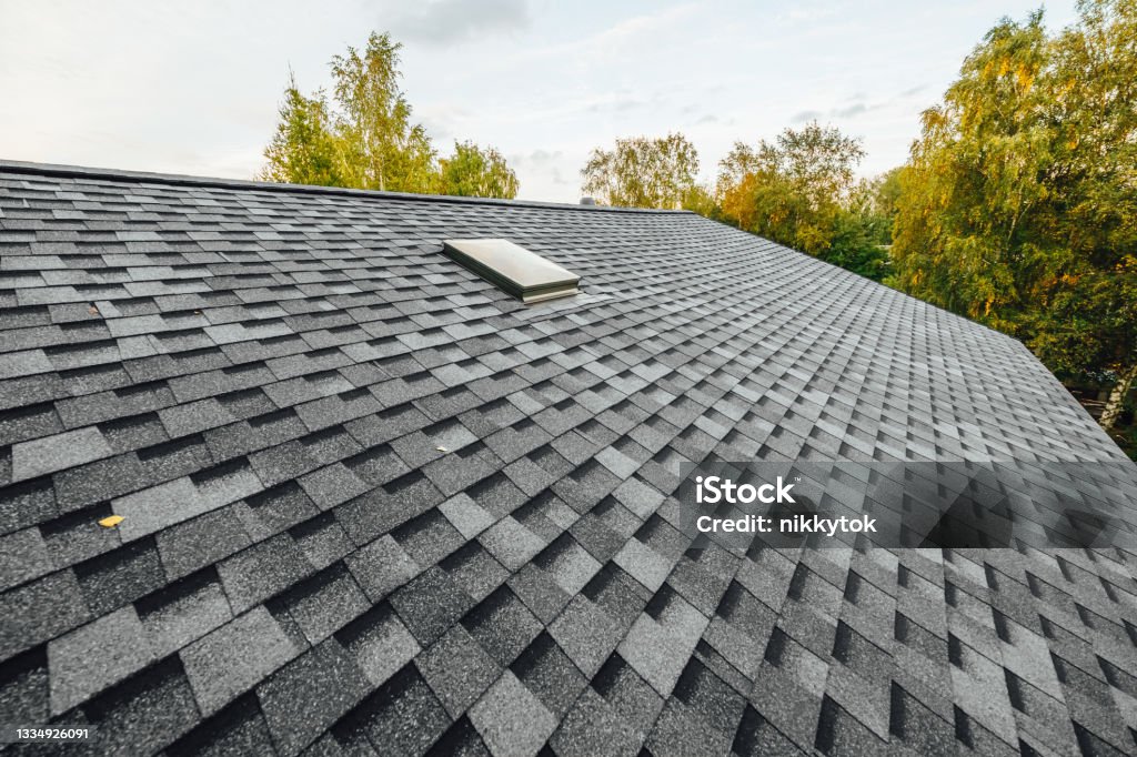 roof of new house with shingles roof-tiles and ventilation window Rooftop Stock Photo