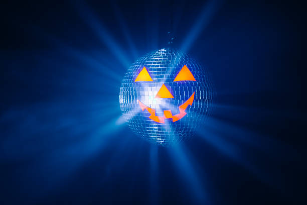 istock Halloween party pumpkin disco ball, blue shiny rays background 1334926126