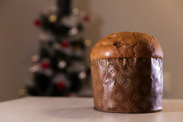 istock Panettone with blurry Christmas lights blinking in the background. 1334928441