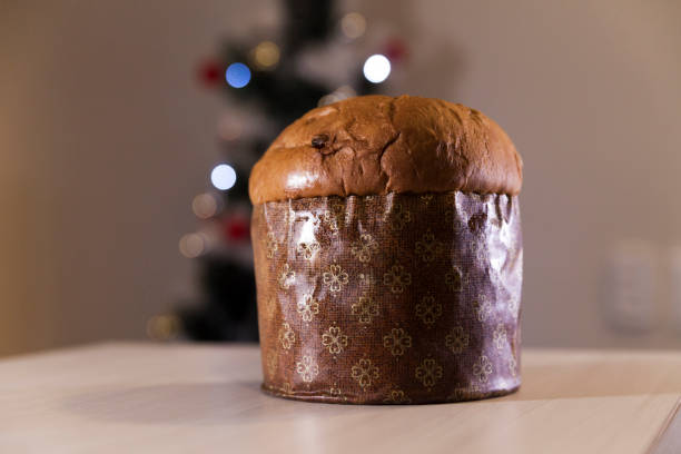 istock Panettone with blurry Christmas lights blinking in the background. 1334928450