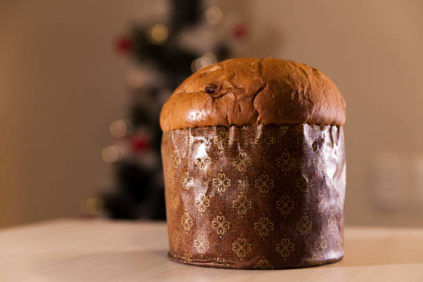 istock Panettone with blurry Christmas lights blinking in the background. 1334928470