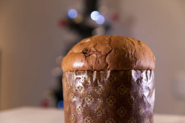 istock Panettone with blurry Christmas lights blinking in the background. 1334928482