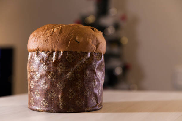istock Panettone with blurry Christmas lights blinking in the background. 1334928532