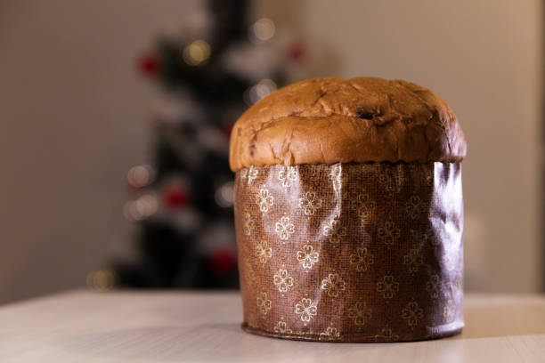 istock Panettone with blurry Christmas lights blinking in the background. 1334928566