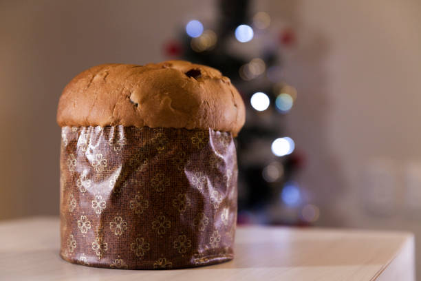 istock Panettone with blurry Christmas lights blinking in the background. 1334928567