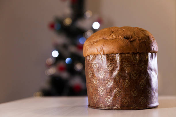 istock Panettone with blurry Christmas lights blinking in the background. 1334928571