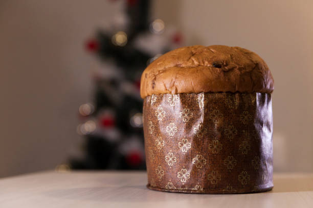istock Panettone with blurry Christmas lights blinking in the background. 1334928587
