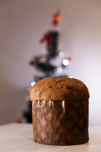 istock Panettone with blurry Christmas lights blinking in the background. 1334928651