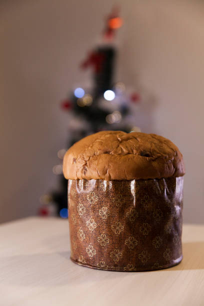 Panettone with blurry Christmas lights blinking in the background.
