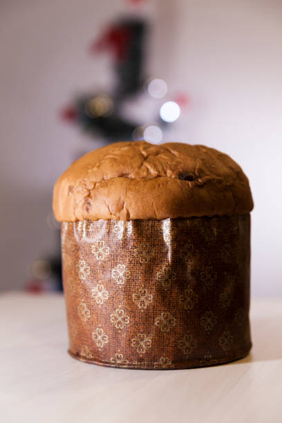 istock Panettone with blurry Christmas lights blinking in the background. 1334928684