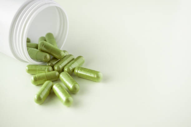 istock Herbal medicine capsules with bottle on white background 1334932246