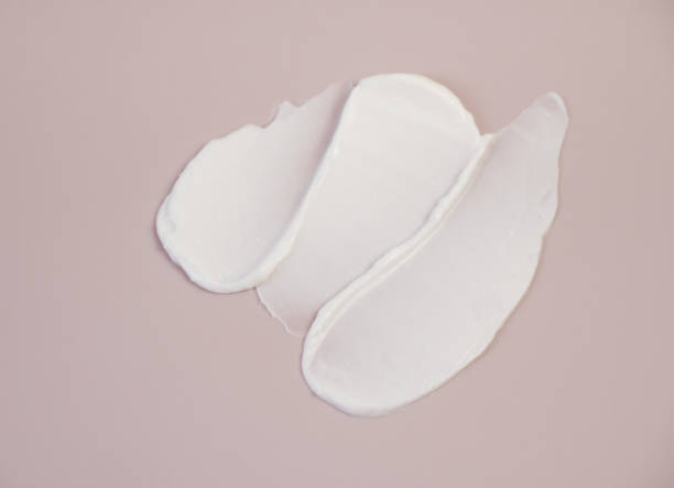 istock White cream texture on a pink background. 1334932753