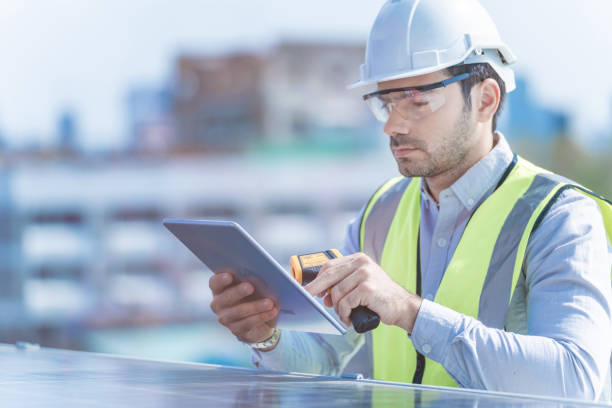 istock engineer man inspects construction of solar cell panel or photovoltaic cell by electronic device. Industrial Renewable energy of green power. factory worker working on tower roof. 1334936126