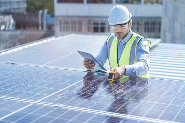 istock engineer man inspects construction of solar cell panel or photovoltaic cell by electronic device. Industrial Renewable energy of green power. factory worker working on tower roof. 1334936133