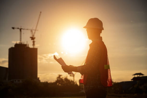 istock male engineer working construction site at Silhouette Sunset time 1334936204