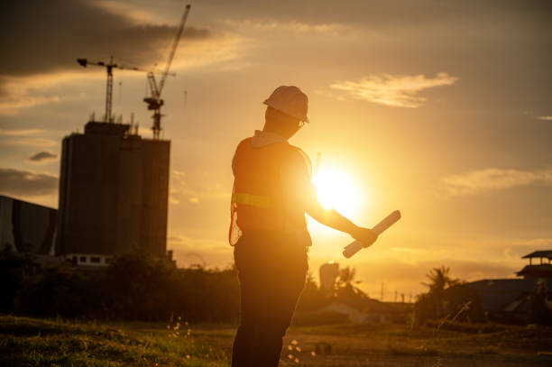istock male engineer working construction site at Silhouette Sunset time 1334936231
