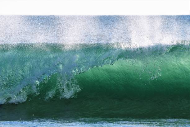 istock Blue green Breaking Ocean Wave with offshore windblown spray 1334936971