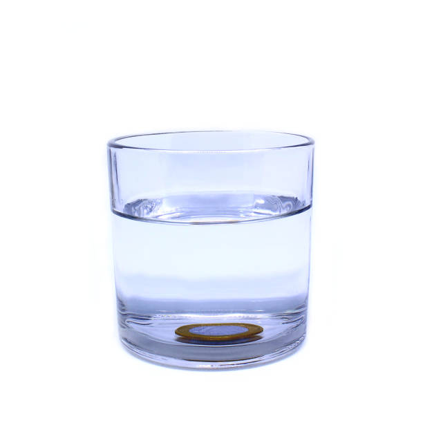 istock Archimedes' principle experiment. Glass with a submerged coin 1334945856