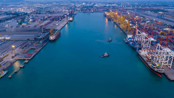 istock Container ship terminal, Unloading and quay crane of container ship at industrial port with shipping container vessel, cargo freight  import export business logistic transportation at twilight in aerial view 1334949872