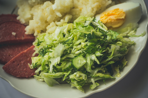 Plate with delicious breakfast with rice, sausage, eggs and salad