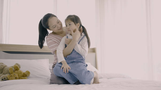 istock Woman loving her daughter on bed 1334962388