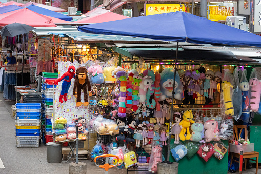 Hong Kong - August 18, 2021 : Chun Yeung Street Market in North Point, Hong Kong. Many dolls and toys are at the stall.