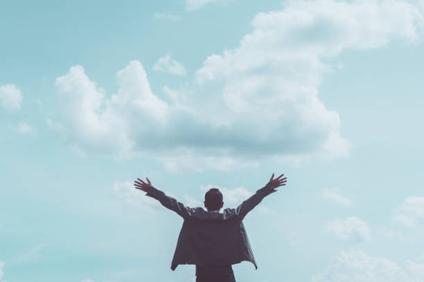 istock Copy space of man rising hands on blue sky white clouds abstract background. 1334970997