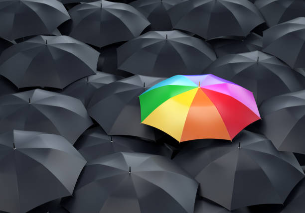 istock Rainbow colored umbrella among dark ones 1334972374