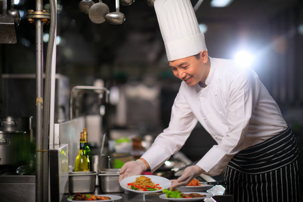 istock Asian Male chef presenting the dish in the kitchen. Selective focus. 1334973259